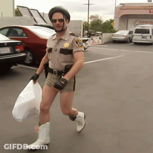 A Man In A Sheriff 'S Uniform Is Carrying A Bag And Wearing Cowboy Boots GIF