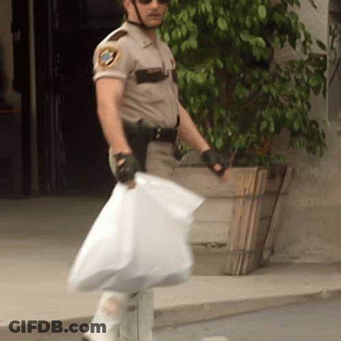 A Man In A Sheriff 'S Uniform Is Holding A Bag GIF