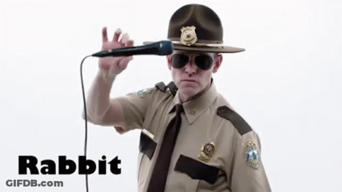 A Man In A Sheriff 'S Uniform Is Singing Into A Microphone With The Word Rabbit Written Below Him GIF