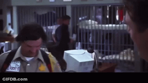 A Man In A Sheriff 'S Uniform Is Talking To Another Man In A Prison Cell GIF