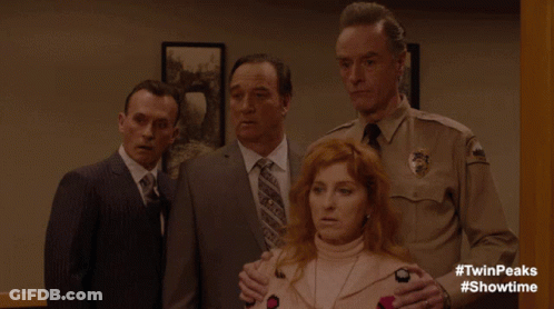 A Man In A Sheriff 'S Uniform Stands Next To A Woman In A Pink Sweater GIF