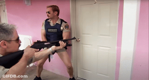 A Man In A Sheriff Uniform Holds A Gun GIF