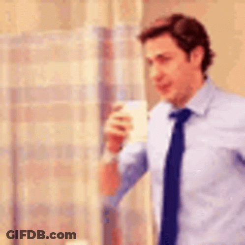 A Man In A Shirt And Tie Is Drinking From A Cup . GIF