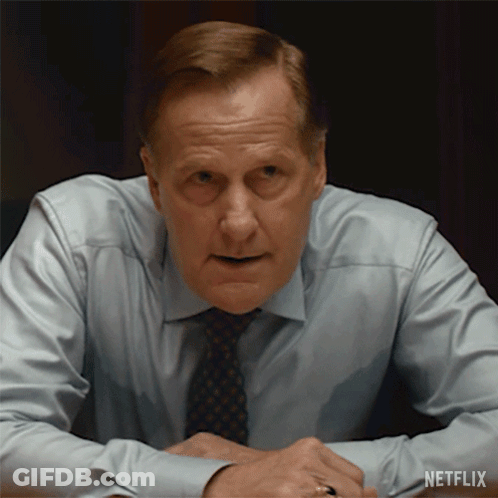 A Man In A Shirt And Tie Is Sitting At A Table With A Netflix Logo On The Bottom Right GIF