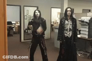 A Man In A Skeleton Costume Is Standing Next To Another Man In A Black Coat GIF