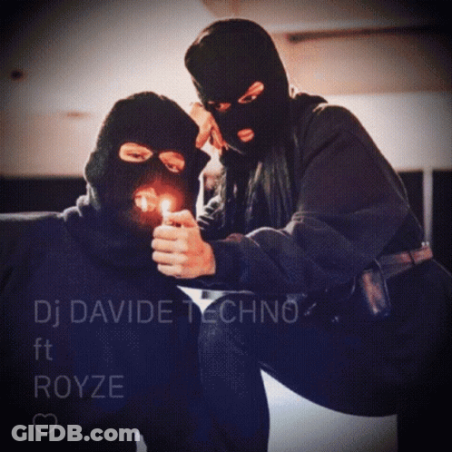 A Man In A Ski Mask Is Lighting A Cigarette Next To A Woman Wearing A Ski Mask GIF