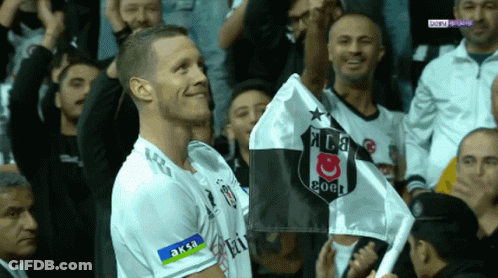 A Man In A Soccer Uniform Holds A Flag That Says Coca Cola On It GIF