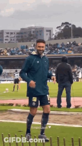 A Man In A Soccer Uniform Is Running On A Field GIF