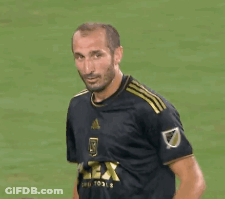 A Man In A Soccer Uniform Is Smiling And Looking At The Camera . GIF