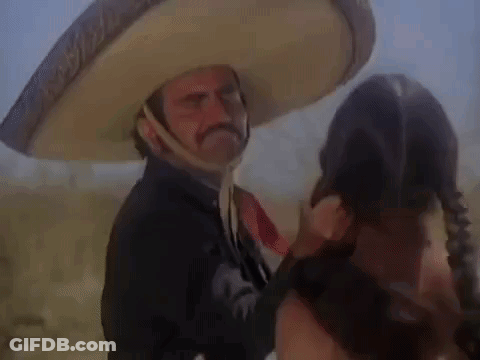 A Man In A Sombrero Is Talking To A Woman In A Field . GIF