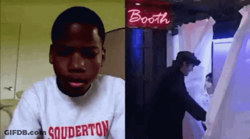 A Man In A Souderton Sweatshirt Is Sitting In Front Of A Booth . GIF