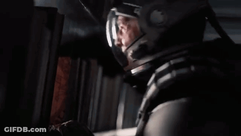 A Man In A Space Helmet Is Looking Out Of A Window . GIF