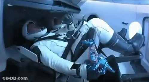 A Man In A Space Suit Is Laying In A Chair In A Space Ship . GIF