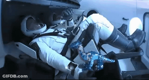 A Man In A Space Suit Is Laying In A Chair With His Feet Up . GIF