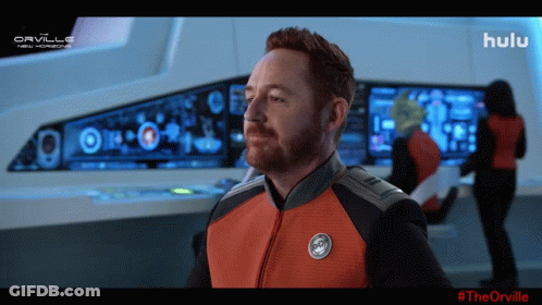 A Man In A Space Suit Is Standing In Front Of A Screen That Says Hulu On It GIF