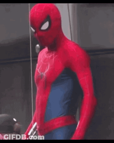 A Man In A Spider Man Costume Is Standing In Front Of A Glass Wall . GIF