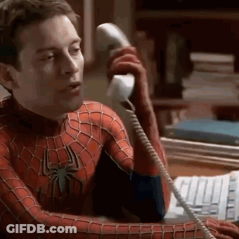 A Man In A Spider-Man Costume Is Talking On A Telephone . GIF