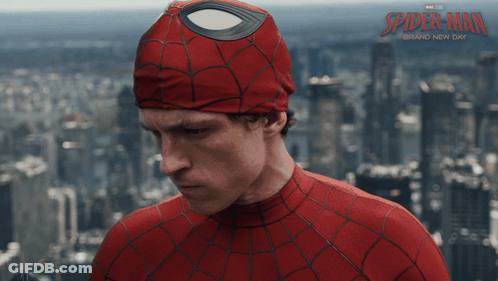 A Man In A Spider Man Costume Stands In Front Of A City Skyline GIF