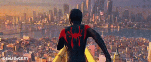 A Man In A Spider-Man Suit Is Standing In Front Of A City Skyline . GIF