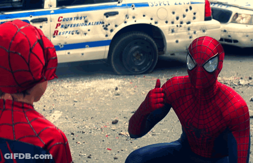 A Man In A Spiderman Costume Giving A Thumbs Up In Front Of A Police Car That Says Courtesy Professionalism Respect GIF