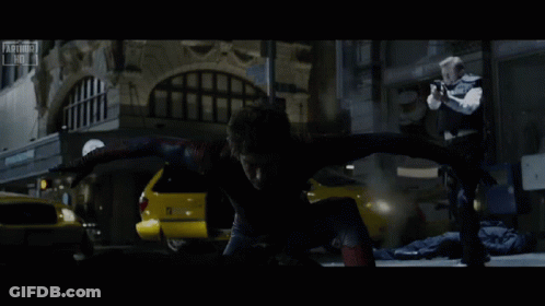 A Man In A Spiderman Costume Is Being Chased By A Man In A Black Vest GIF