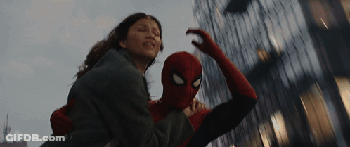 A Man In A Spiderman Costume Is Carrying A Woman GIF