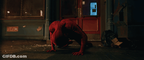 A Man In A Spiderman Costume Is Crawling On The Sidewalk GIF