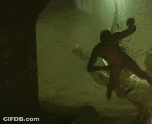 A Man In A Spiderman Costume Is Crawling Through A Dark Cave GIF