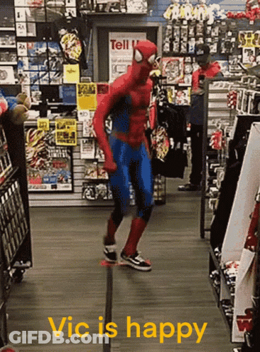 A Man In A Spiderman Costume Is Dancing In A Store With The Words Vic Is Happy Below Him GIF