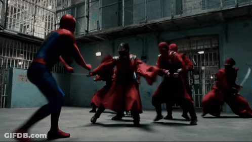 A Man In A Spiderman Costume Is Fighting A Group Of People In Red Robes GIF