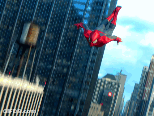 A Man In A Spiderman Costume Is Flying Through The Air In A City GIF