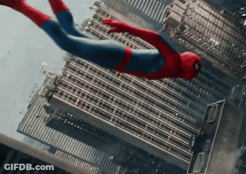 A Man In A Spiderman Costume Is Flying Through The Air Over A City GIF