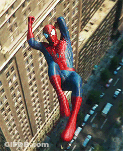 A Man In A Spiderman Costume Is Hanging From The Side Of A Building GIF