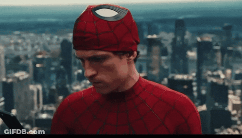 A Man In A Spiderman Costume Is Holding A Sword In Front Of A City Skyline GIF