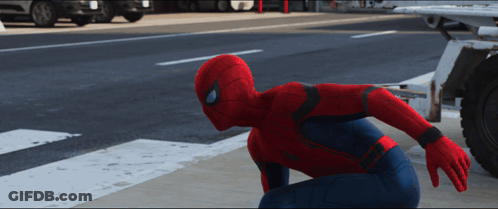 A Man In A Spiderman Costume Is Kneeling Down On The Side Of The Road GIF