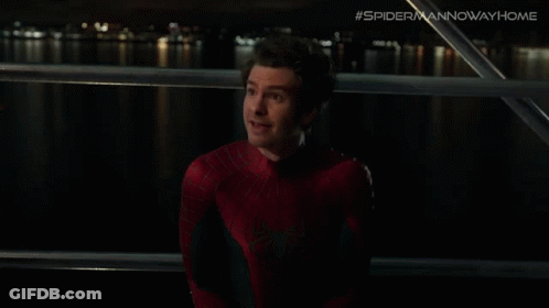 A Man In A Spiderman Costume Is Looking At Something GIF