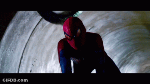 A Man In A Spiderman Costume Is Looking Down At Something GIF