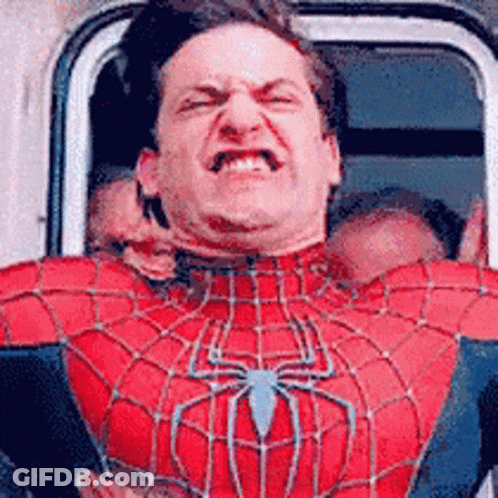 A Man In A Spiderman Costume Is Making A Funny Face While Sitting In A Car . GIF