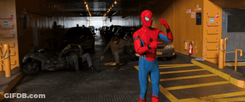 A Man In A Spiderman Costume Is Pointing At Something GIF