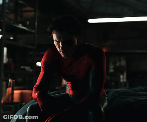 A Man In A Spiderman Costume Is Sitting Down GIF