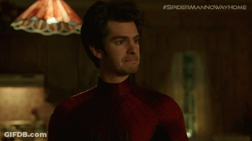 A Man In A Spiderman Costume Is Standing In Front Of A Lamp And A Sign That Says #Spidermannowwayhome GIF