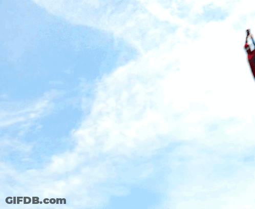 A Man In A Spiderman Costume Is Standing On A Roof GIF