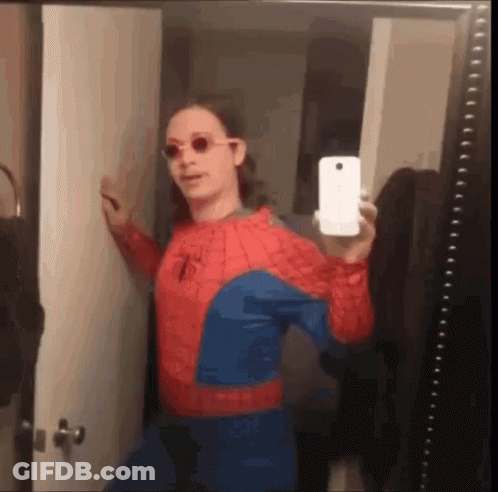 A Man In A Spiderman Costume Is Taking A Selfie In A Bathroom Mirror . GIF