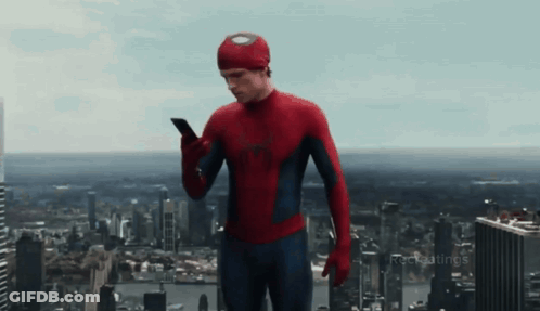 A Man In A Spiderman Costume Is Using A Cell Phone GIF