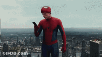 A Man In A Spiderman Costume Is Using A Cell Phone GIF