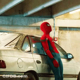 A Man In A Spiderman Costume Leans Against A White Car GIF