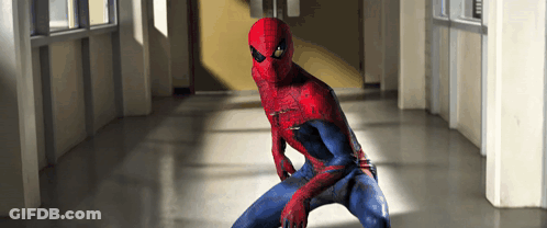 A Man In A Spiderman Costume Stands In A Hallway GIF