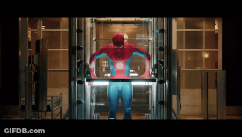 A Man In A Spiderman Costume Stands In An Elevator GIF