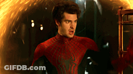 A Man In A Spiderman Costume Stands In Front Of A Fire GIF
