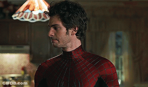 A Man In A Spiderman Costume Stands In Front Of A Lamp GIF